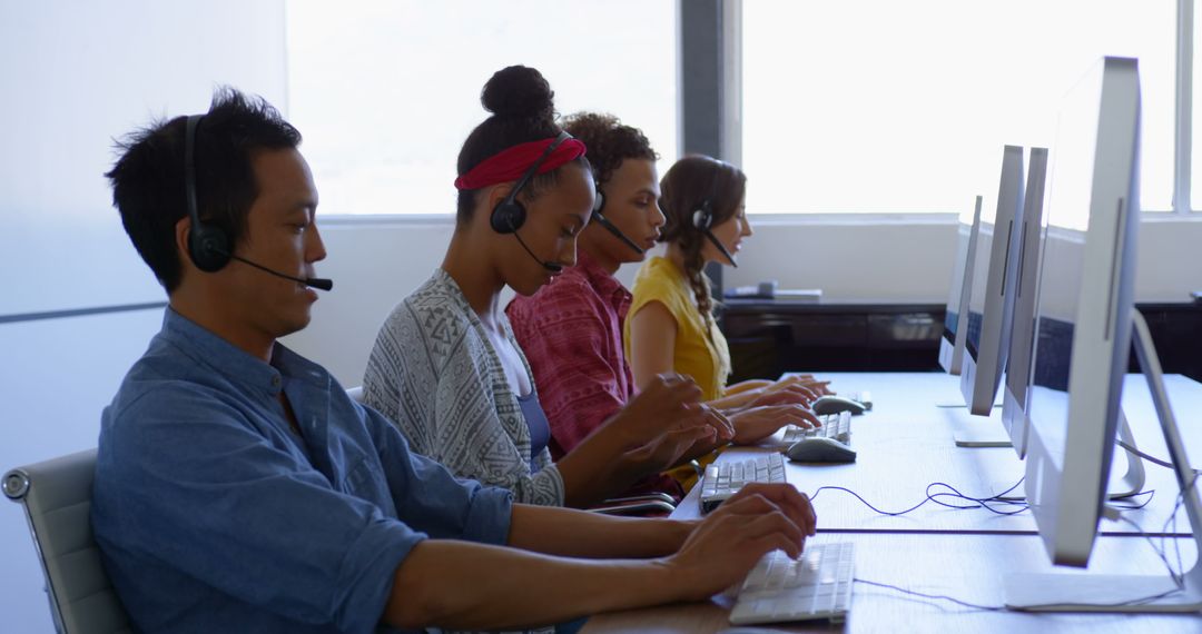 Diverse Call Center Operators Using Headsets in Modern Office