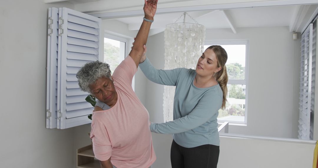 Young Physiotherapist Assisting Senior Woman with Stretching Exercise at Home - Free Images, Stock Photos and Pictures on Pikwizard.com