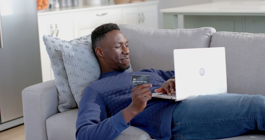 Man Laying on Couch Shopping Online with Laptop - Free Images, Stock Photos and Pictures on Pikwizard.com