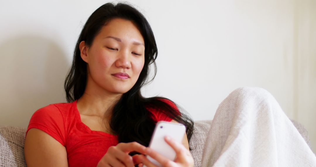 Content Woman Relaxing on Sofa Using Smartphone