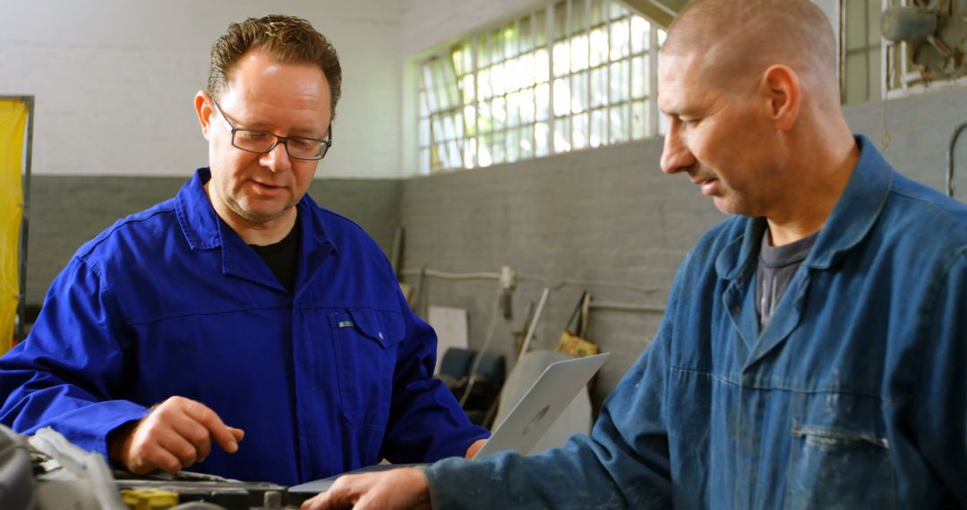 Mechanic and Supervisor Collaborating in Industrial Workshop - Free Images, Stock Photos and Pictures on Pikwizard.com