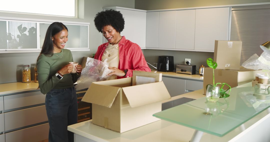 Diverse Couple Unpacking Moving Box in Modern Kitchen