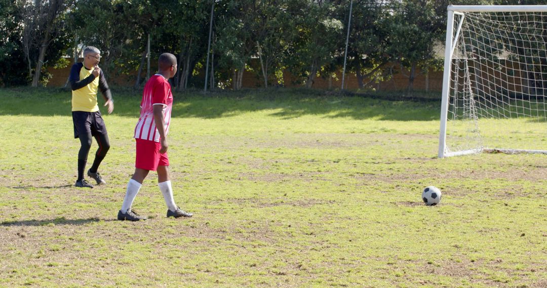 Youth Soccer Player Preparing to Shoot as Goalie Readies in Background