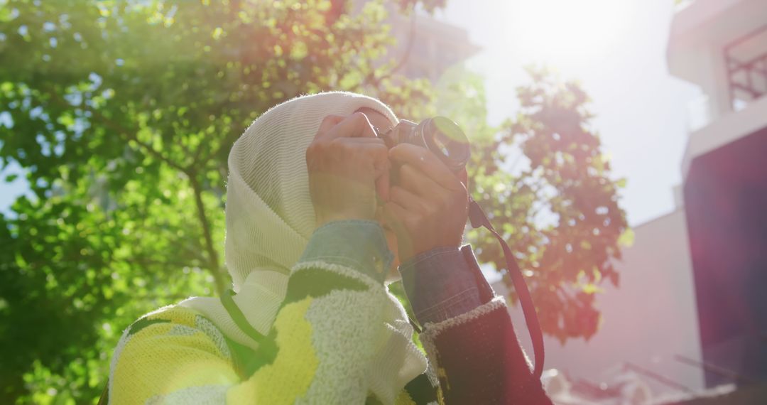 Woman in Hijab Taking Photographs Outdoors on Sunny Day - Free Images, Stock Photos and Pictures on Pikwizard.com