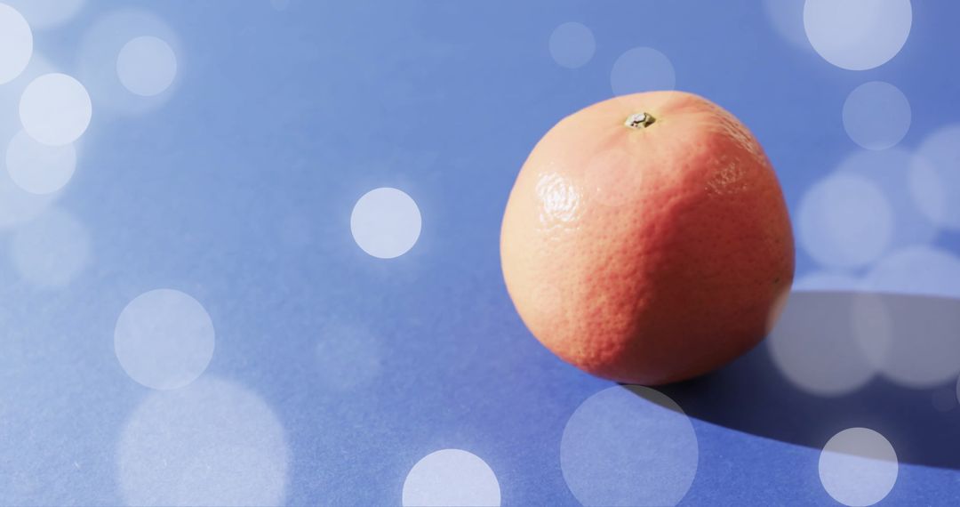 Fresh Grapefruit on Vivid Blue Background with Light Spots