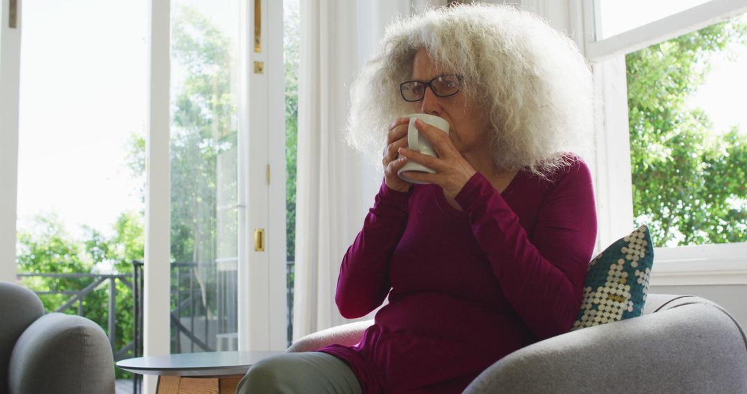 Senior Woman Relaxing at Home Drinking Coffee by Window - Free Images, Stock Photos and Pictures on Pikwizard.com