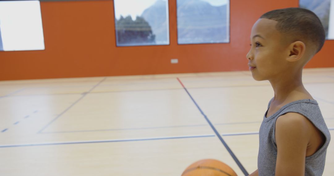 Young Boy Experiencing Basketball Fun in Gym