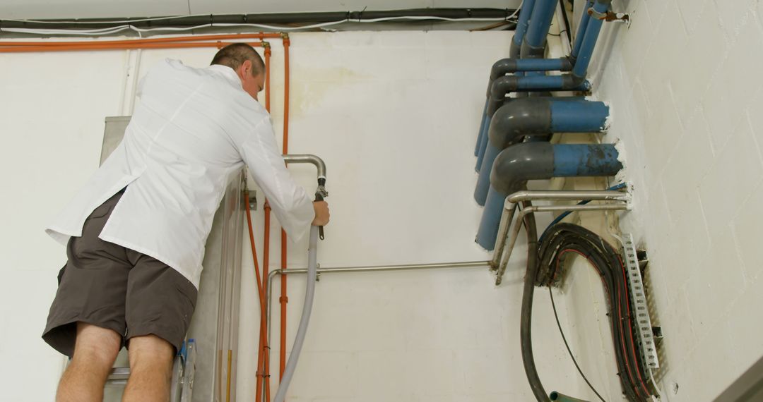 Technician Installing Industrial Pipes in Control Room - Free Images, Stock Photos and Pictures on Pikwizard.com