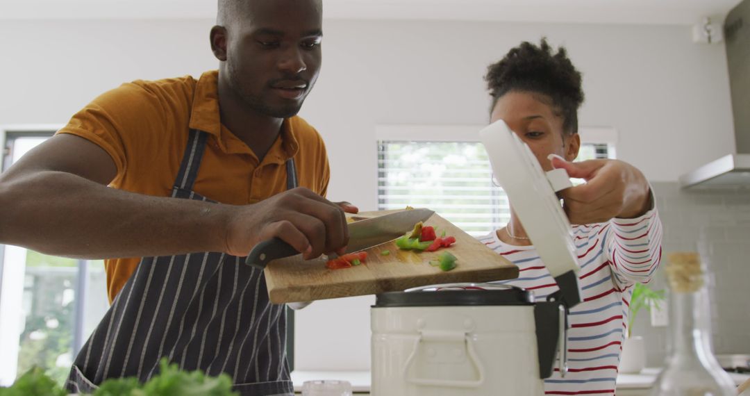 Image of happy african american couple cooking together in kitchen - Free Images, Stock Photos and Pictures on Pikwizard.com