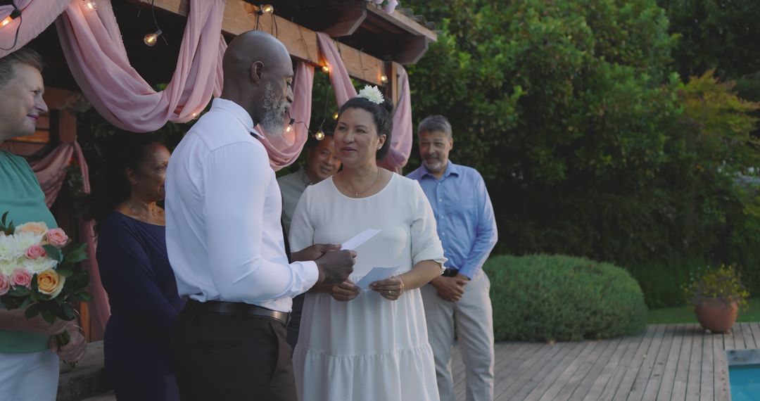 Senior Diverse Couple Exchanging Vows at Outdoor Garden Ceremony