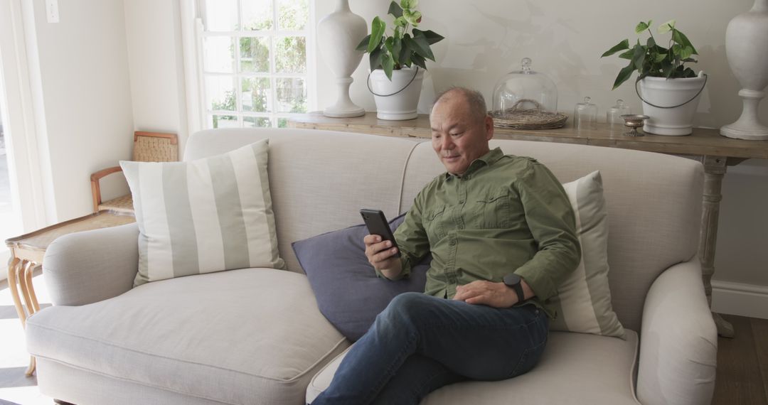 Senior Man Relaxing at Home with Smartphone