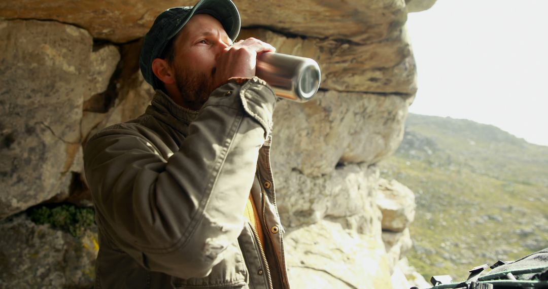 Outdoor Hiker Drinking from Thermos in Rocky Landscape - Free Images, Stock Photos and Pictures on Pikwizard.com