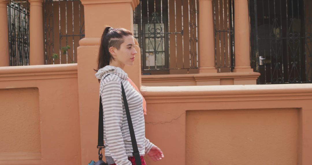 Young Woman Walking in Urban Area Wearing Casual Outfit - Free Images, Stock Photos and Pictures on Pikwizard.com