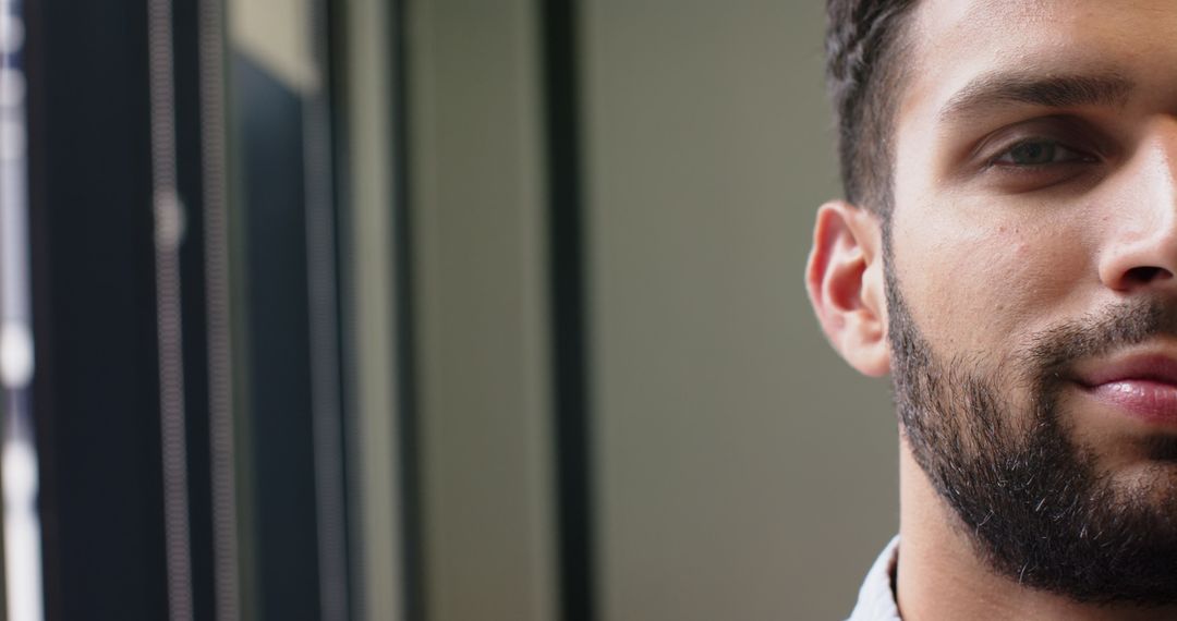 Confident Bearded Man Indoors with Contemplative Expression