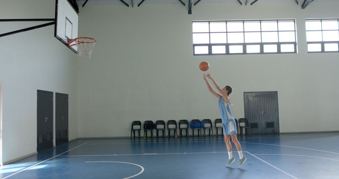 Female Basketball Player Practicing Shot in Empty Gym