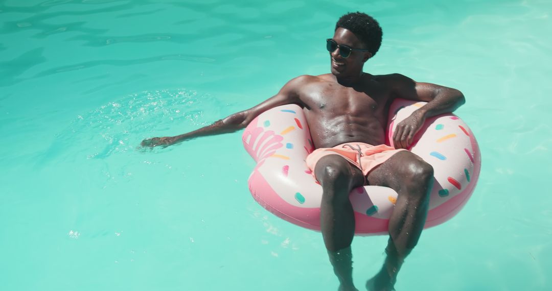 African American Man Relaxing on Donut Inflatable Pool Float