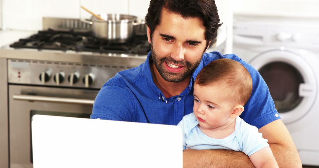 Father Working from Home with Baby on Lap in Kitchen - Free Images, Stock Photos and Pictures on Pikwizard.com