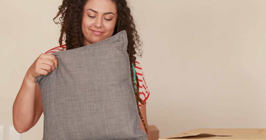 Woman Packing Grey Pillow During Move - Free Images, Stock Photos and Pictures on Pikwizard.com