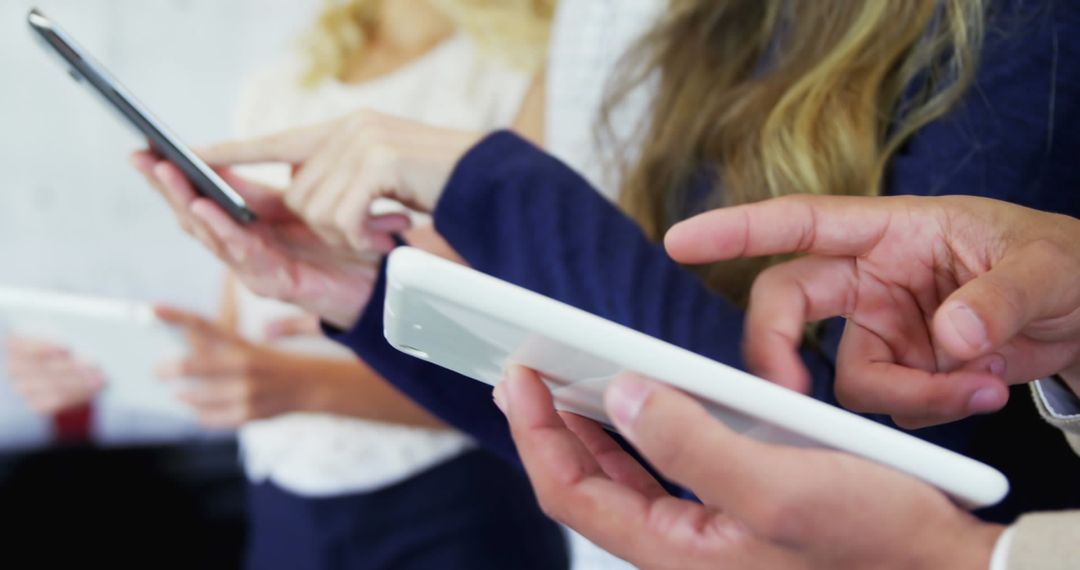 Close-up of Hands Using Tablets in Collaborative Workspace