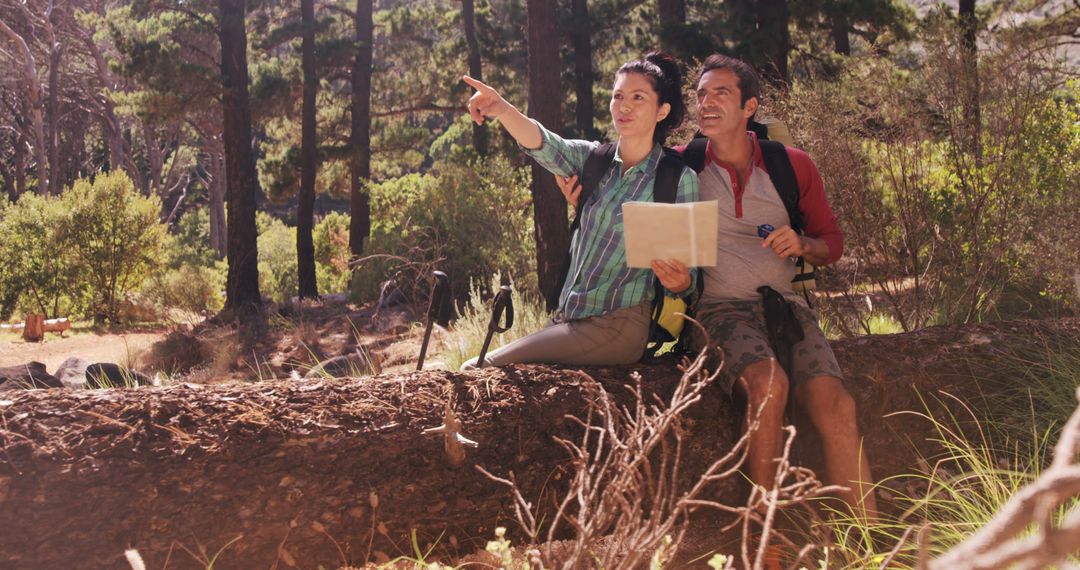Excited Couple Navigating Forest Trail while Resting