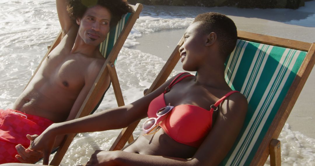 Couple Relaxing on Beach Loungers by Ocean - Free Images, Stock Photos and Pictures on Pikwizard.com