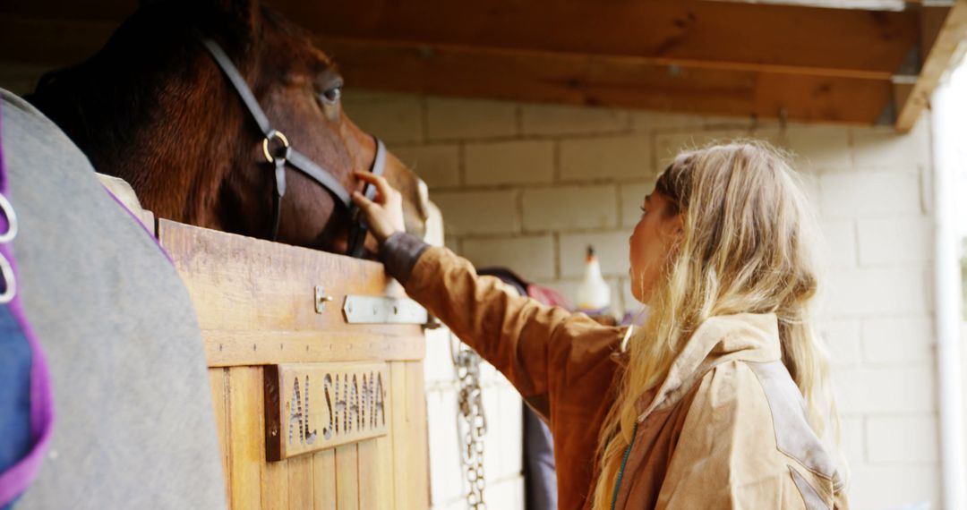 Young girl tending to horse in stable - Free Images, Stock Photos and Pictures on Pikwizard.com