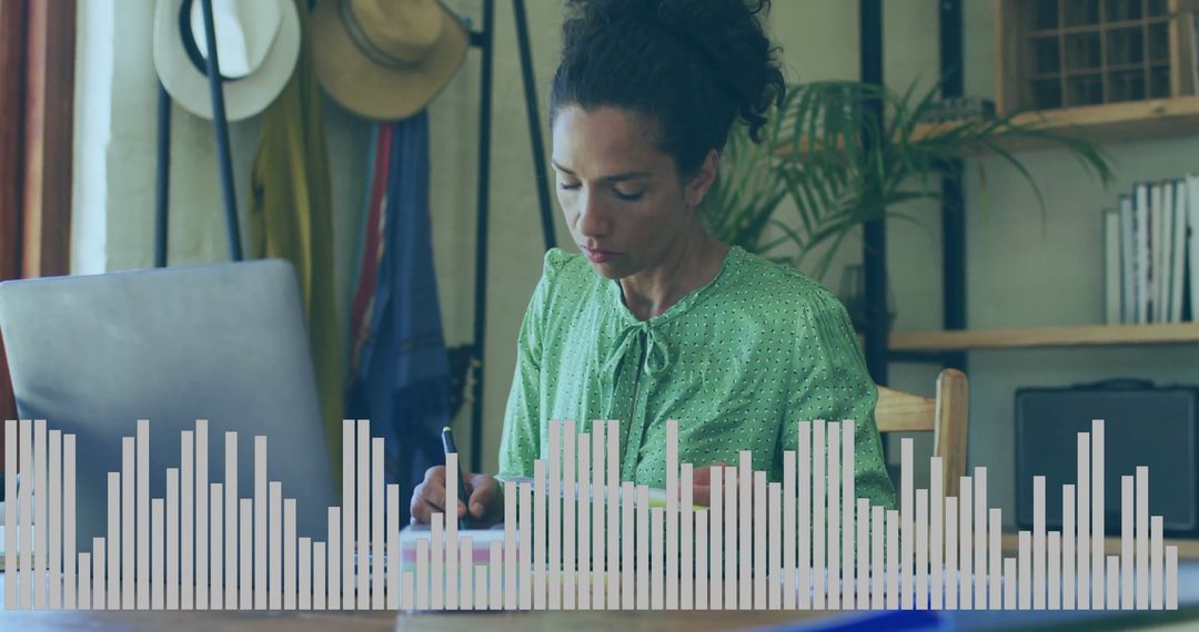 Focused Woman in Home Office Writing and Using Laptop
