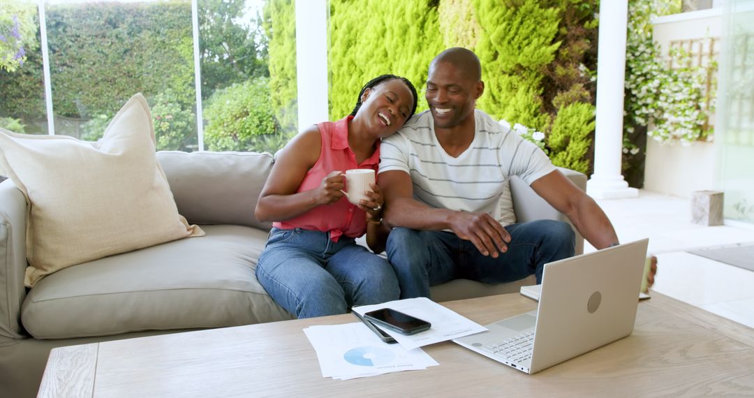 Smiling Couple Using Laptop While Relaxing At Home