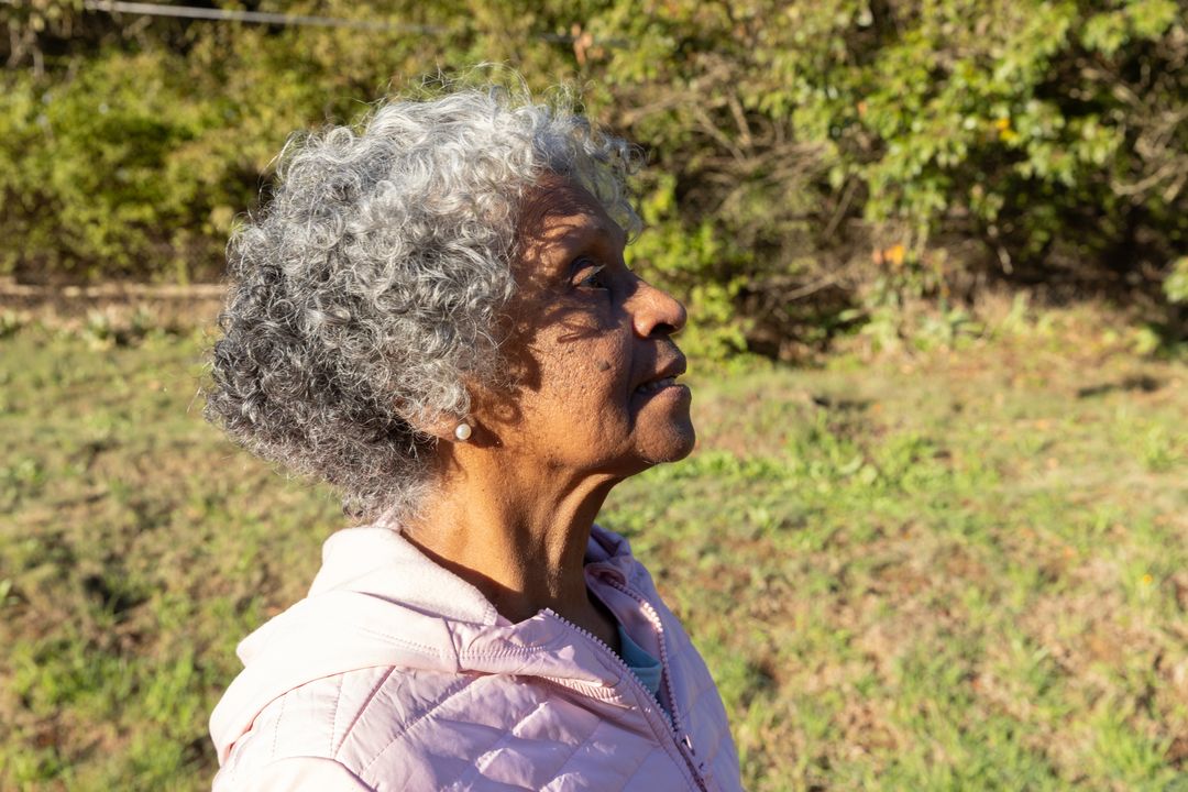 Senior Woman Enjoying Sunny Day in Tranquil Field