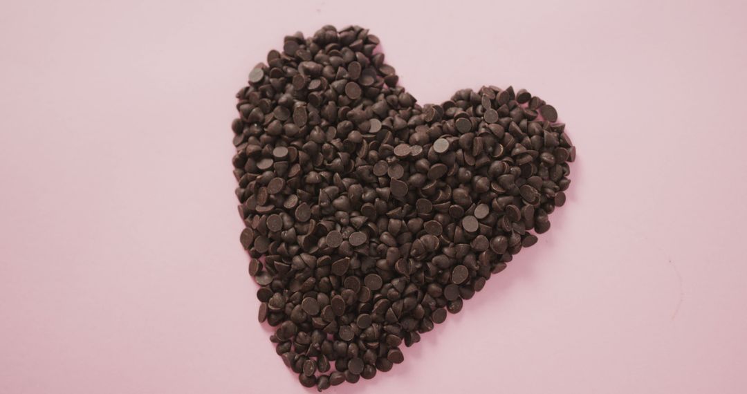 Heart-Shaped Arrangement of Chocolate Chips on Pink Background - Free Images, Stock Photos and Pictures on Pikwizard.com