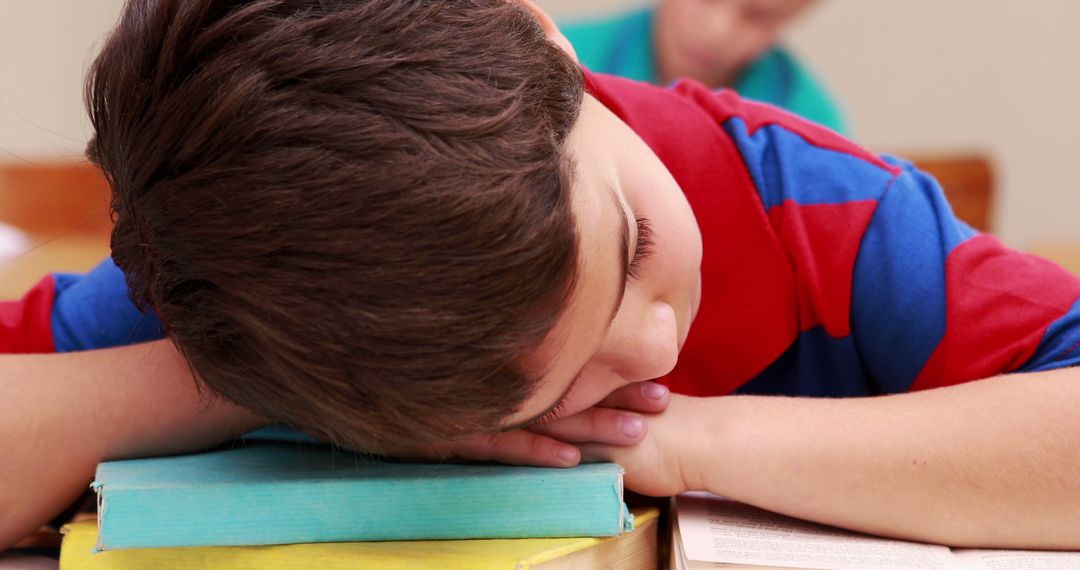 Young Boy Sleeping on Desk with Books in Classroom - Free Images, Stock Photos and Pictures on Pikwizard.com