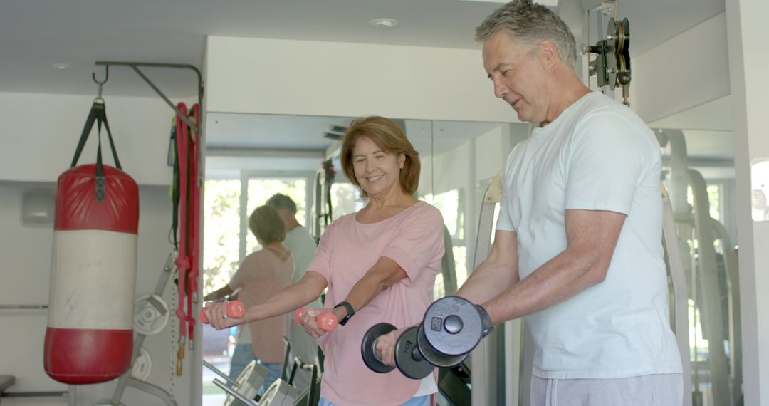 Senior Couple Exercising with Dumbbells at Home Gym
