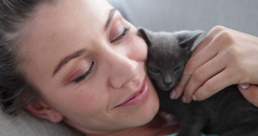 Woman Sharing Loving Moment with Tiny Kitten at Home