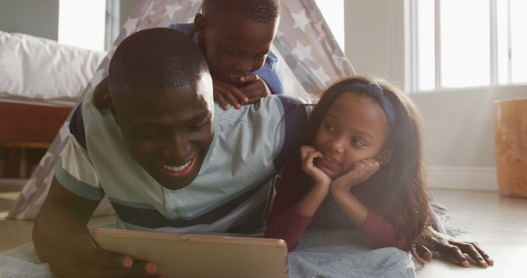 Happy African American Father and Children Watching Tablet Together at Home - Free Images, Stock Photos and Pictures on Pikwizard.com