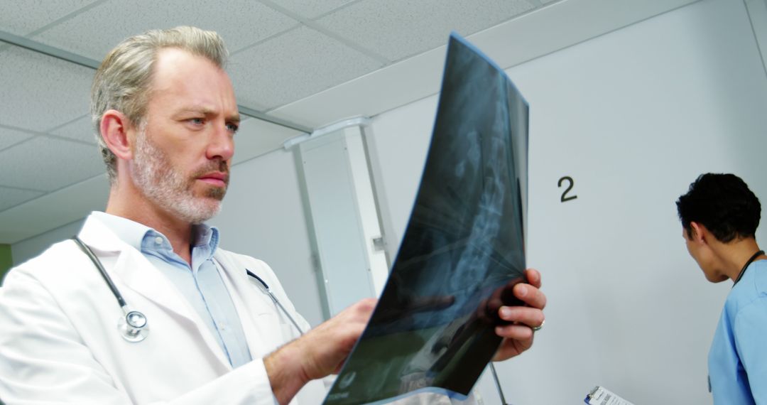 Senior Doctor Analyzing X-Ray Film in Hospital - Free Images, Stock Photos and Pictures on Pikwizard.com