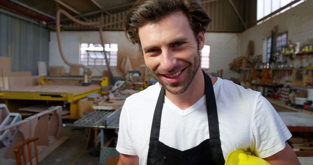 Smiling Male Carpenter in Workshop Holding Hard Hat - Free Images, Stock Photos and Pictures on Pikwizard.com