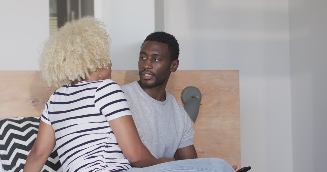 African American Couple Smiling Together on Bed, Expressing Joy and Intimacy