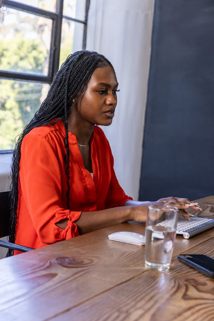 Focused Professional Working on Keyboard at Bright Employees Desk