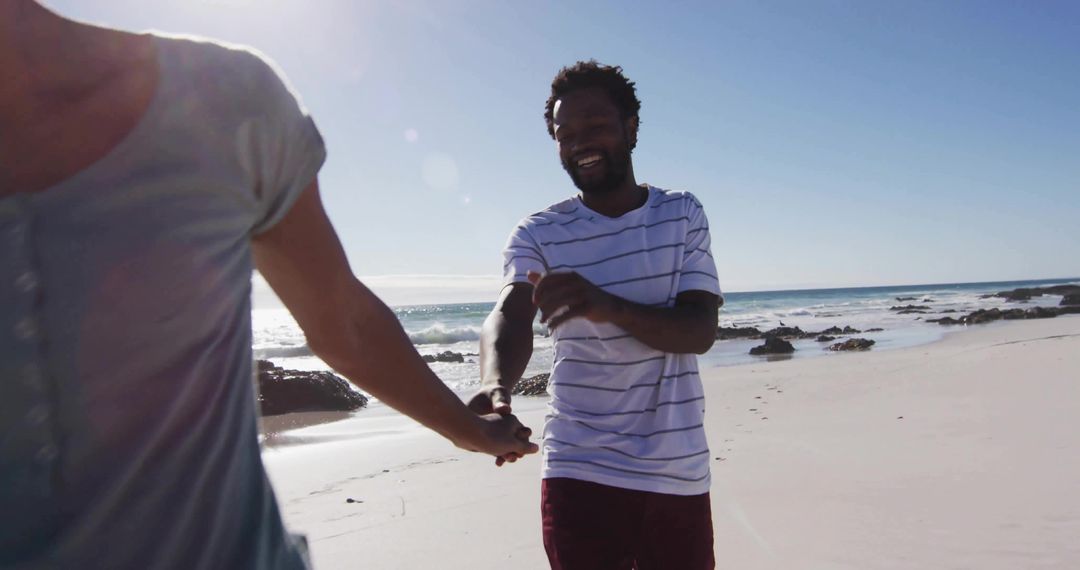 Romantic Couple Strolling Along Sunlit Beach Holding Hands