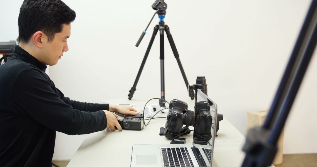 Man Working with Camera Equipment in Photography Studio - Free Images, Stock Photos and Pictures on Pikwizard.com