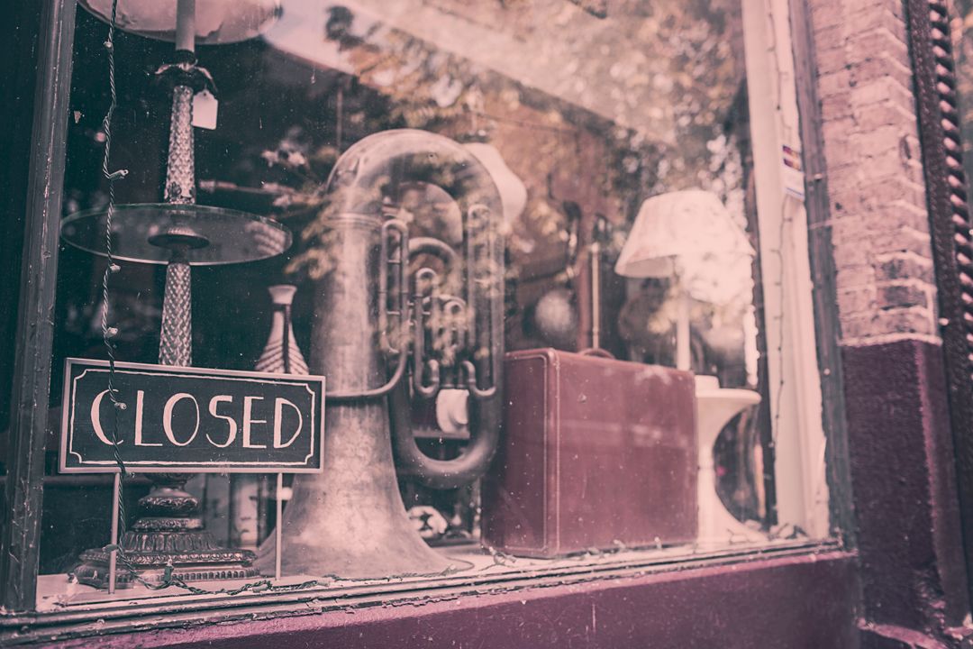 Vintage shop display with musical instrument including a tuba and closed sign