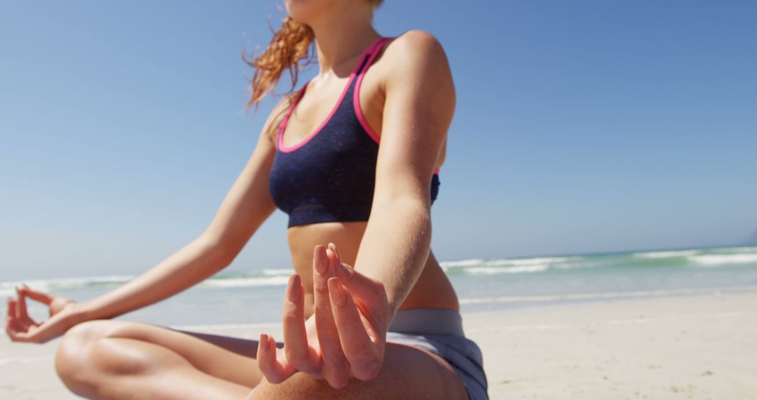 A young Caucasian woman practices yoga on a sunny beach, with copy space - Free Images, Stock Photos and Pictures on Pikwizard.com