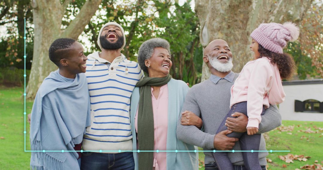Multigenerational family laughing and hugging in autumn park, grandparents with child