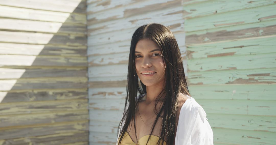 Woman Smiling Outside near Wooden Wall on Sunny Day - Free Images, Stock Photos and Pictures on Pikwizard.com