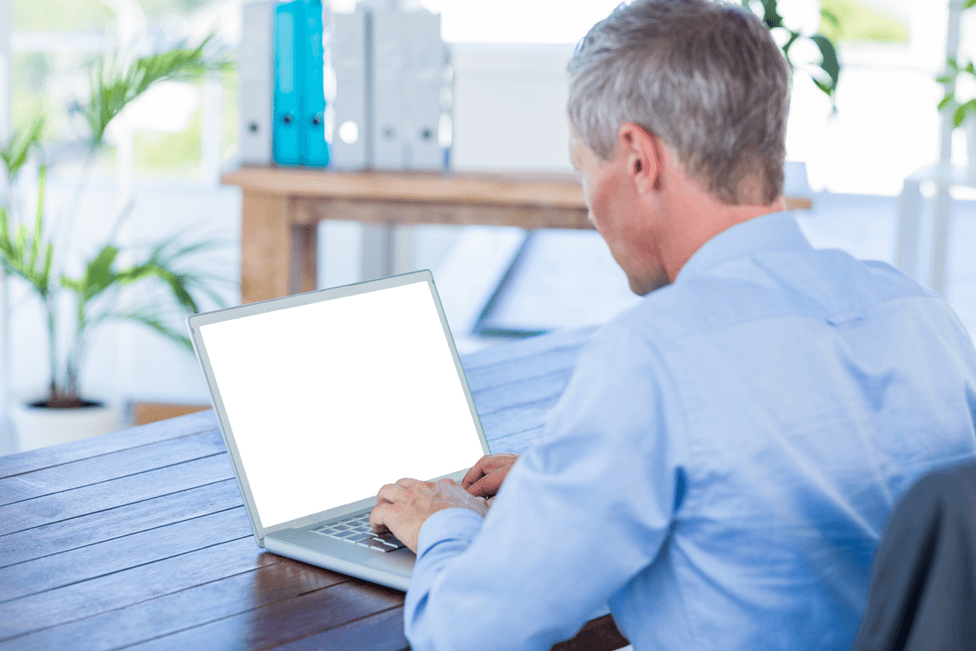 Senior Businessman Using Laptop in Bright Office with Transparent Screen