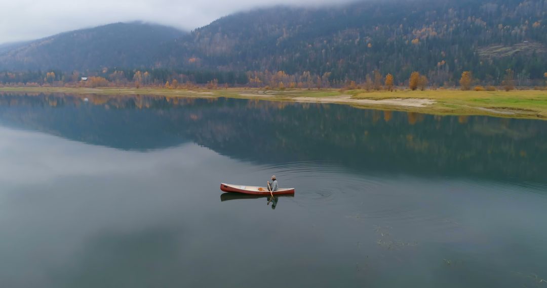 Man Canoeing Alone on Serene Mountain Lake - Free Images, Stock Photos and Pictures on Pikwizard.com