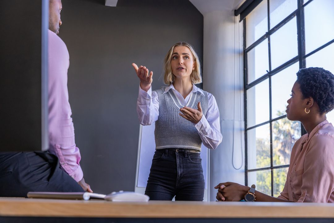 Diverse Team Discussing in Contemporary Office Near Large Window