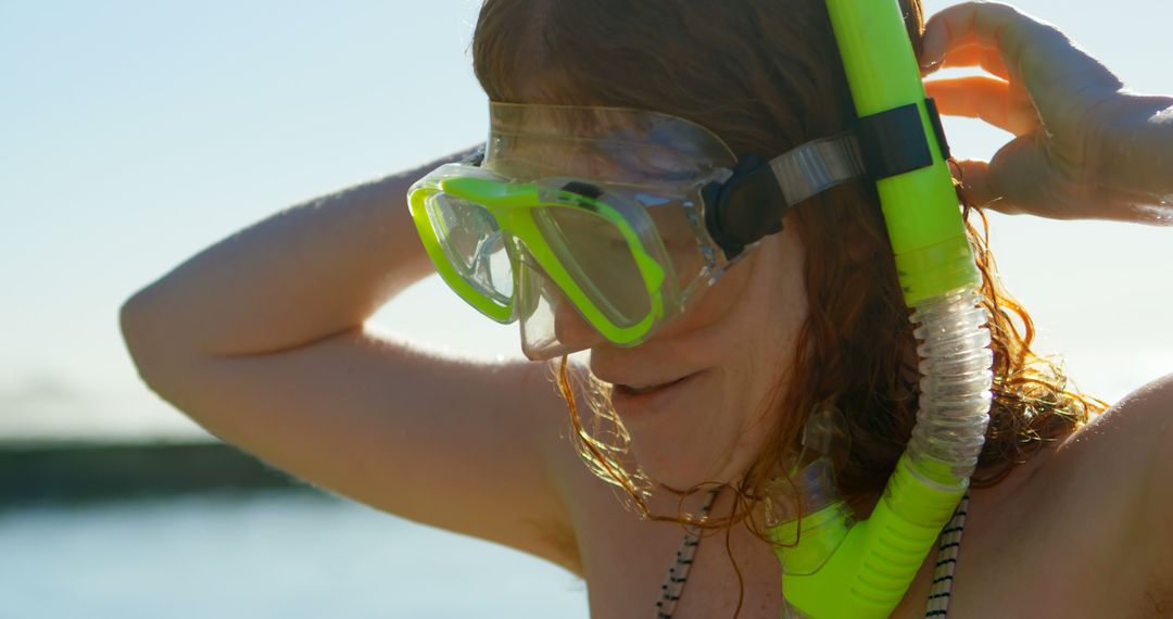 Woman Adjusting Scuba Mask at Sunny Beach - Free Images, Stock Photos and Pictures on Pikwizard.com