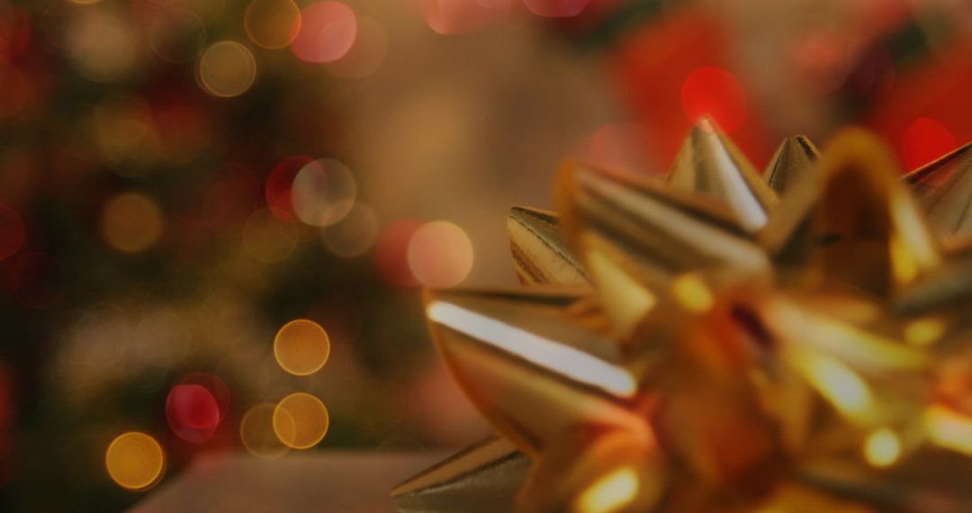 Closeup of Gold Christmas Bow with Warm Bokeh Background