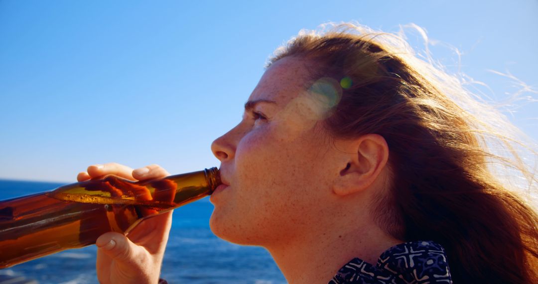 Woman Enjoying Beer by Ocean on Sunny Day - Free Images, Stock Photos and Pictures on Pikwizard.com